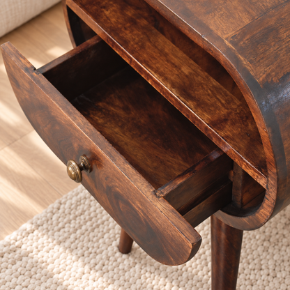 Overhead close-up of the walnut-finish bedside table with its drawer open, showing the wooden storage compartment.
