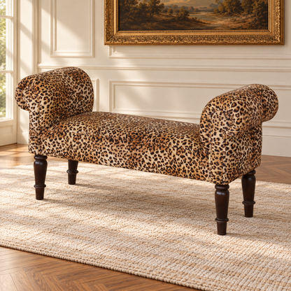 Three-quarter view of the leopard-print velvet salon bench with rolled arms and turned wood legs on an ivory rug.