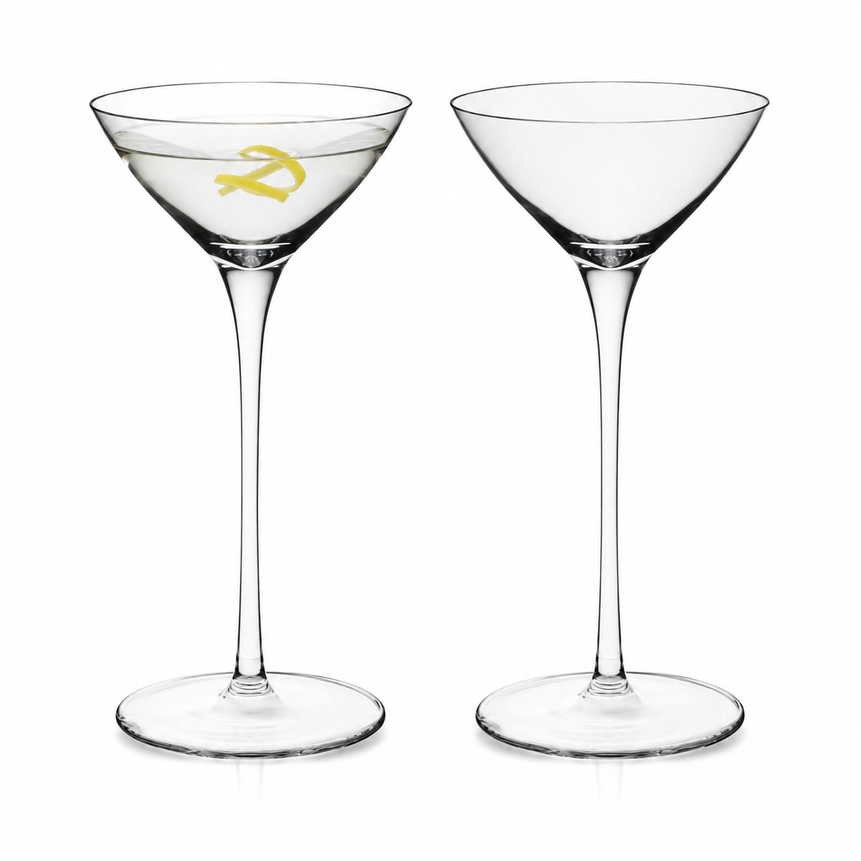 Two small martini glasses, one filled with cocktail and lemon twist