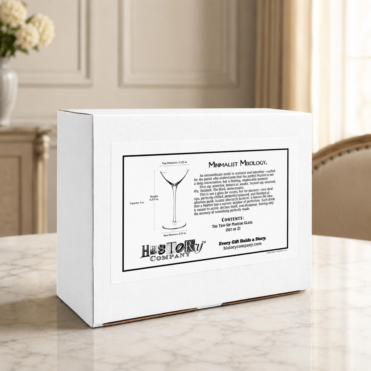 Two-sip martini glass gift box set on marble dining table